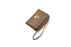 Detail of vintage brown leather wallet featuring embossed floral patterns and a gold C-clasp