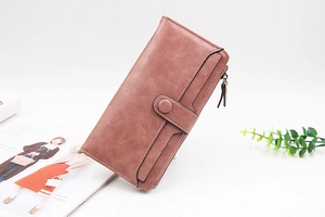 Dettaglio del portafoglio lungo rosa in pelle PU con chiusura a fibbia e vani per carte