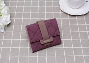 Gros plan du portefeuille tricolore bordeaux avec motif floral et boucle marron
