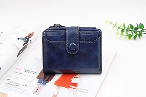 Deep blue faux leather wallet on a fashion magazine with multi-slot card details