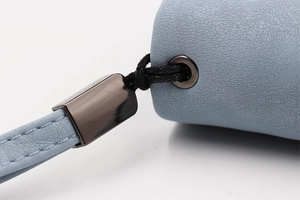 Detail of light blue lychee pattern leather wallet with metal eyelet and wrist strap