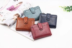 Flat lay of vintage PU leather wallets in brown, blue, and red on a fashion magazine