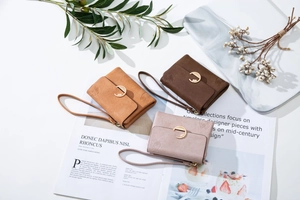 Three-fold leather wallets with embossed floral patterns and golden ring clasps