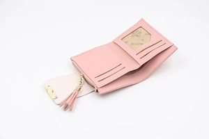 Pink faux leather bifold wallet detail showing card slots and zipper tassel coin pocket