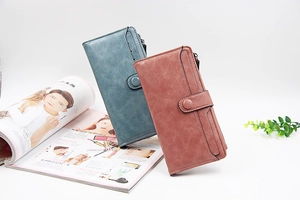 Dettaglio di portafogli lunghi in pelle PU blu e rosa vintage con chiusura a bottone a pressione