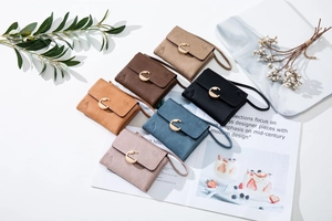 Close-up of small leather wallets in six colors with gold C-buckle and floral texture