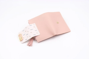 Detail view of pink PU leather wallet featuring leaf print flap and gold leaf hardware