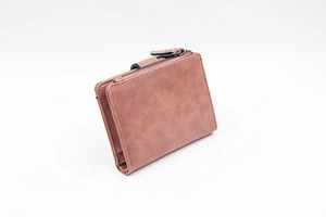 Close-up of matte pink short wallet showing zipper pocket and contrast stitching detail