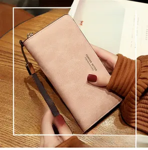 Détail du portefeuille long en similicuir rose avec fermeture éclair et dragonne