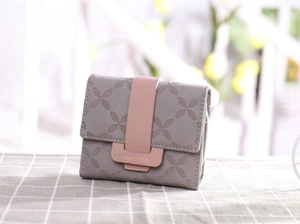 Détail du portefeuille à carreaux gris avec fermoir rose et gaufrage trèfle