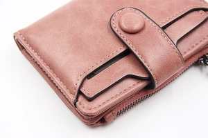 Close-up of minimalist pink PU leather wallet with snap closure and zipper pocket