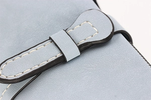 Detailed macro shot of light blue leather wallet with white stitching and zipper closure