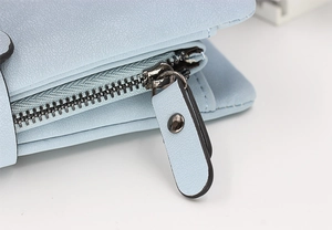 Detail of sky blue long wallet with lychee pattern texture and smooth metal zipper