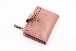 Close-up of matte PU leather dusty pink short wallet with zipper pocket and snap closure
