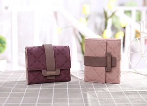 Détail de la texture florale gaufrée et du fermoir sur ce portefeuille chic pour femmes