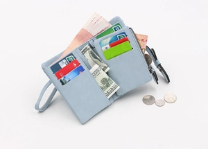 Detail view of the open light blue suede wallet showing card slots and coin pocket