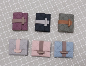 Vue à plat de six portefeuilles pliables colorés pour femmes avec motifs floraux gaufrés