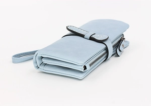 Detail view of light blue long faux leather wallet with side strap and metal zipper closure