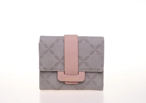 Détail du portefeuille à trois volets gris et rose avec gaufrage floral et fermoir doré