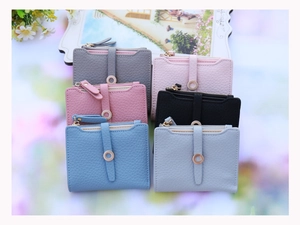 Close-up of small zipper wallets in six colors with litchi grain leather texture