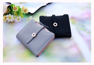 Close-up of litchi grain PU leather texture and metal buckle on women short wallet