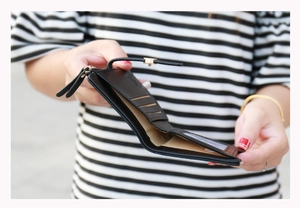 Detailed view of women's black leather wallet interior with card slots and bill compartment