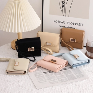 Flat lay of multiple color options for women's short wallets with elegant metal bow clasps