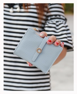 Close-up of light blue pebbled leather wallet with gold zipper and PRETTYS metal buckle