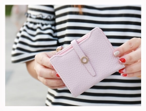 Detailed view of pink lychee leather wallet with gold ring buckle and smooth metal zipper