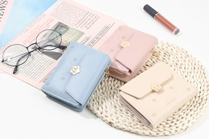 Detailed view of floral embossed short wallets in pastel colors with gold flower clasp