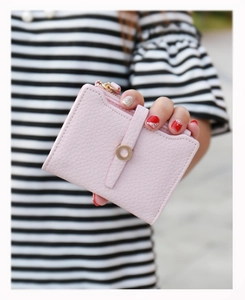 Detailed view of pink pebble leather short wallet with gold buckle and zip closure