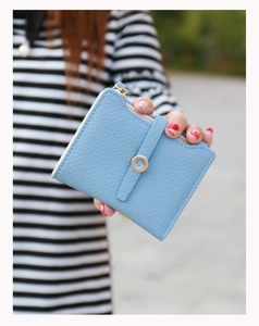 Close-up of light blue zip wallet with lychee leather texture and ring buckle detail