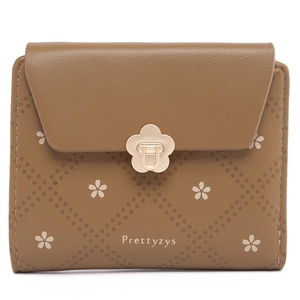 Detail of floral print on brown textured leather wallet with gold flower snap closure