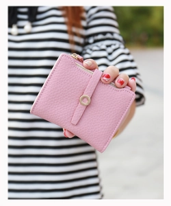 Close-up of pink litchi grain leather wallet with golden ring buckle and side zipper