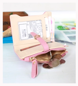 Detail view of pink leather bifold wallet featuring card slots and a gold zipper coin pocket