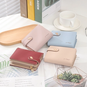 Close-up of minimalist women's short leather wallets with leaf clasp and metal zipper pocket