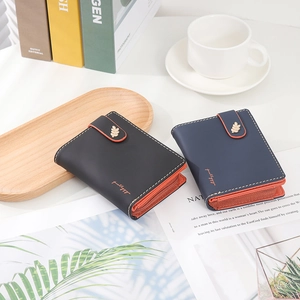 Detail of short wallets with leaf metal clasp and contrast stitching in urban setting