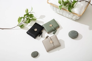 Nahaufnahme minimalistischer Damen-Geldbörsen in drei Farben mit floralem Metallverschluss