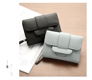 Detail of short leather wallets with lychee texture and overlapping buckle closure