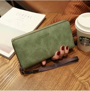 Detail of green long faux leather wallet with gold zipper and Forever Young logo text
