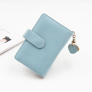 Detail of light blue minimalist wallet featuring matte texture and tassel pendant detail