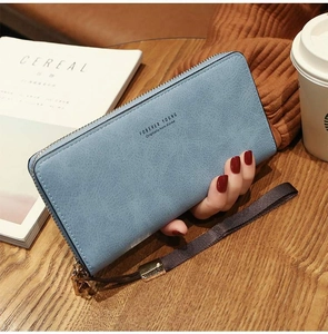 Close-up of light blue long zipper wallet with wrist strap on a wooden table