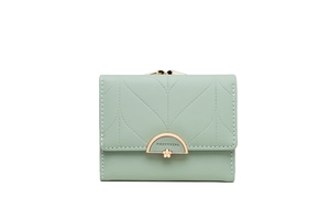 Macro detail of mint green quilted leather wallet with elegant gold metal hardware