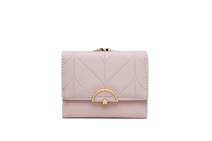 Macro detail of leaf-patterned stitching and golden floral metal clasp on pink purse