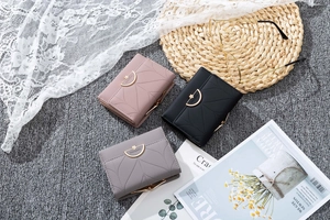 Short tri-fold wallets in pink, black, and grey with leaf pattern stitching and gold clasps