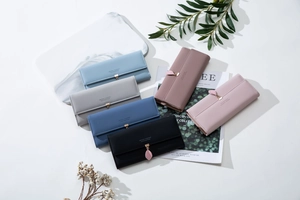 Detailed flat lay of long leather wallets with leaf pendants in six assorted colors