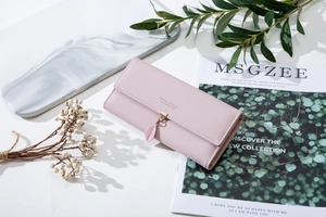 Detail of pink long wallet with matte PU leather, gold leaf pendant and lettering