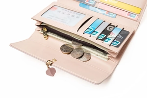 Detail of light pink long wallet showing card slots, ID window, and zipper pocket interior