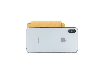 Close-up of leaf pattern embossing on yellow leather wallet with phone storage