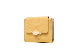 Detail of yellow trifold wallet showing leather texture and gold leaf metal buckle